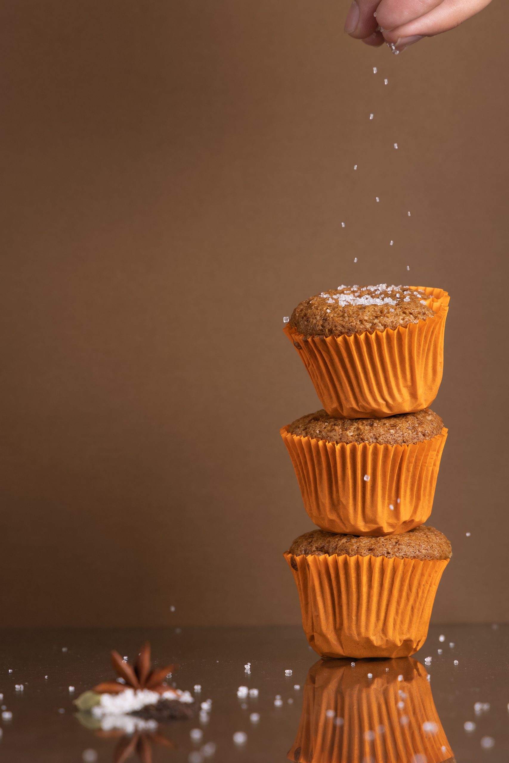 Stack of muffins with sugar falling from a sieve