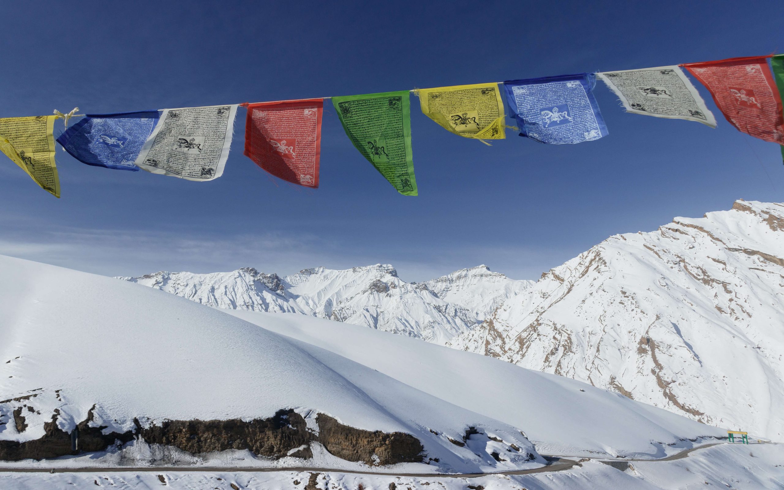 Prayer flags strung above a snowfield