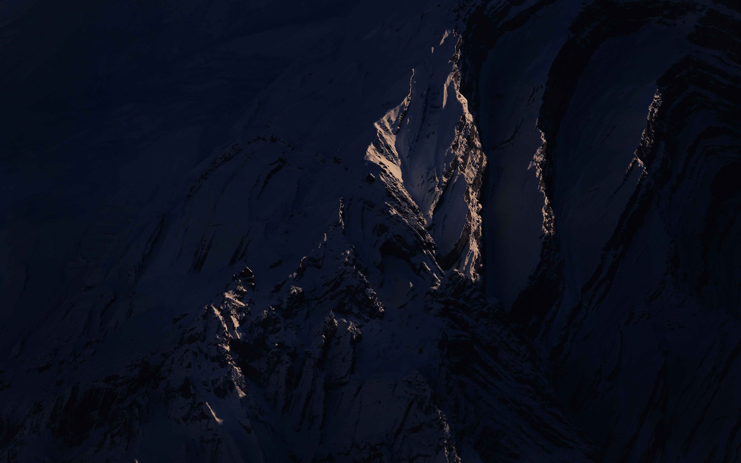 Dark rock face streaked with snow
