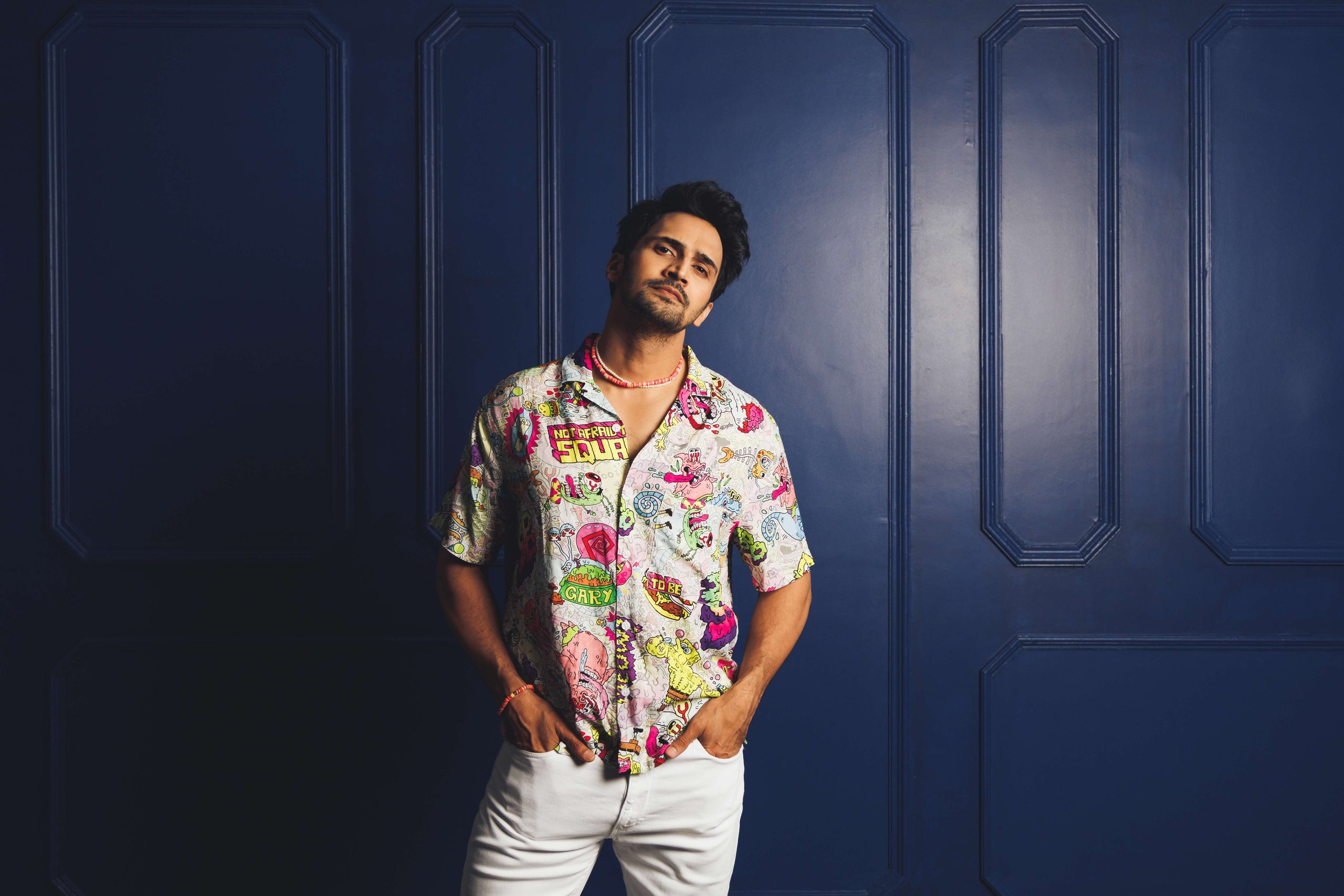 Model in a floral shirt against a navy door